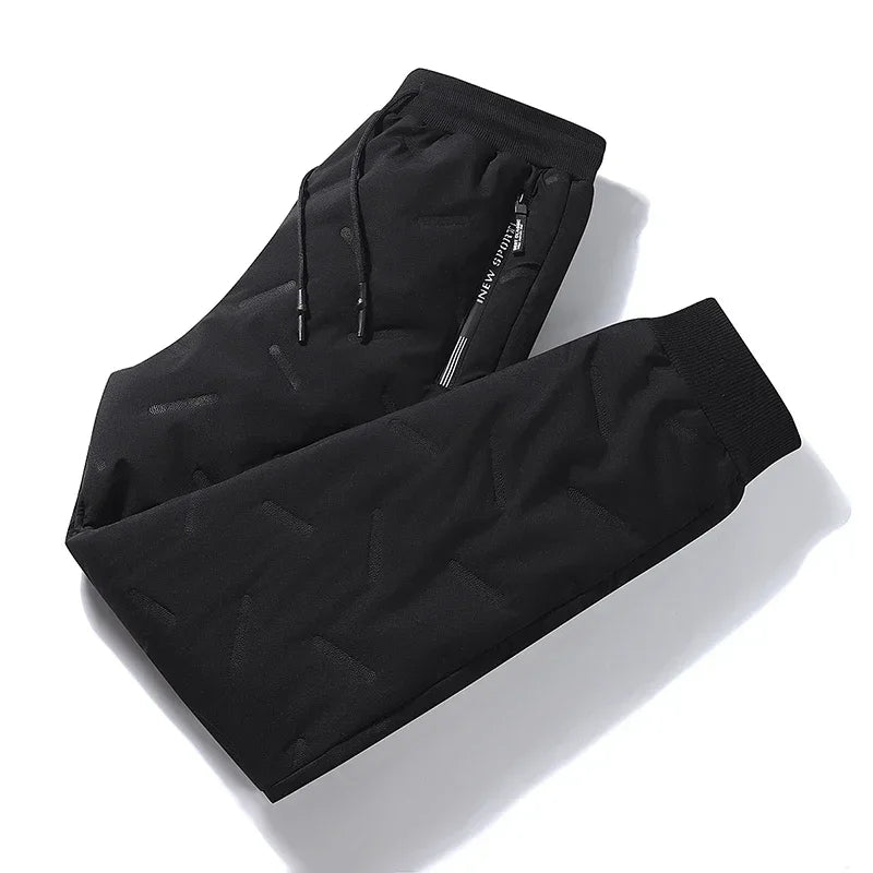 Black waterproof winter down ski pants with adjustable drawstring and elastic cuffs for comfort and warmth.