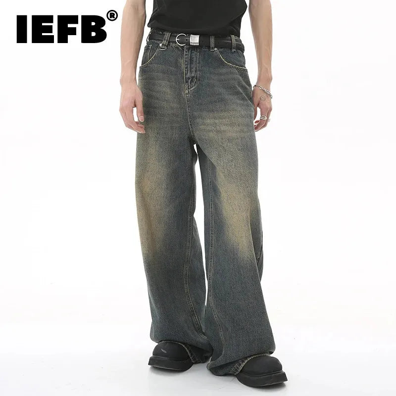 old blue washed denim pants worn by a model, featuring wide legs and a casual style.