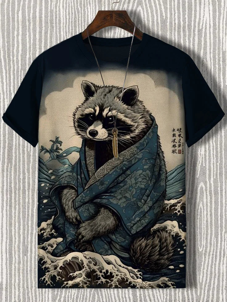 Black t-shirt featuring a raccoon in a blue robe, with a stylized wave background and artistic details.