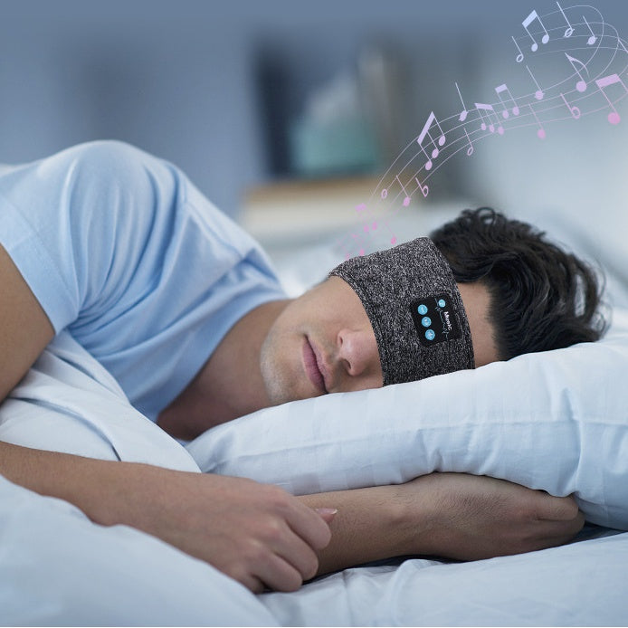 Man sleeping comfortably in a wireless Bluetooth headband, enjoying music with a peaceful expression.