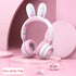 Cute white pink rabbit ear wireless headphones with luminous features on a pastel background.