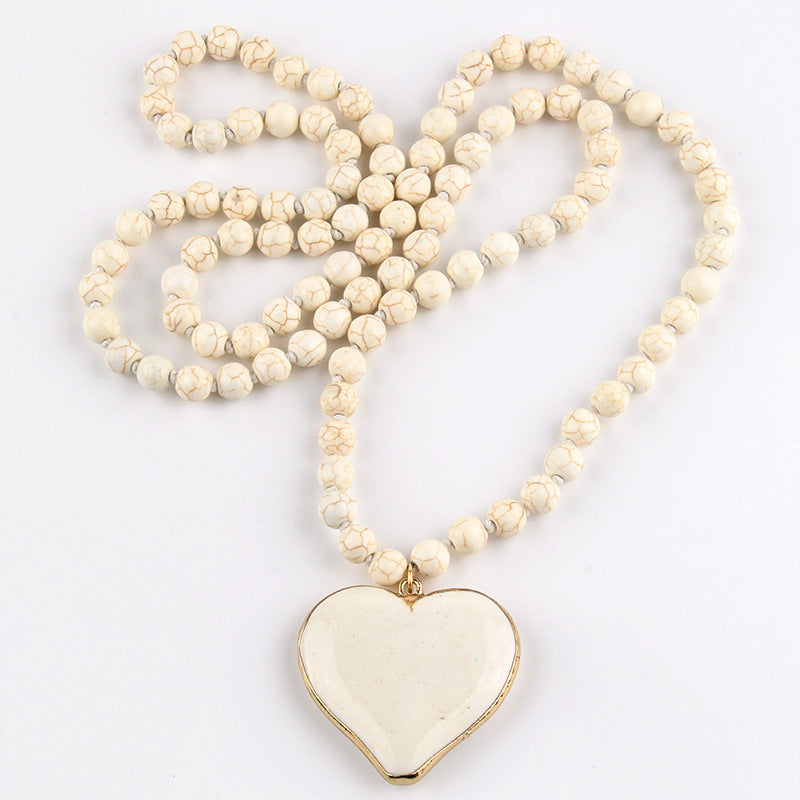 Vintage ethnic bohemian handmade necklace with heart-shaped mother pearl pendant and turquoise pearl chain. Unisex design.