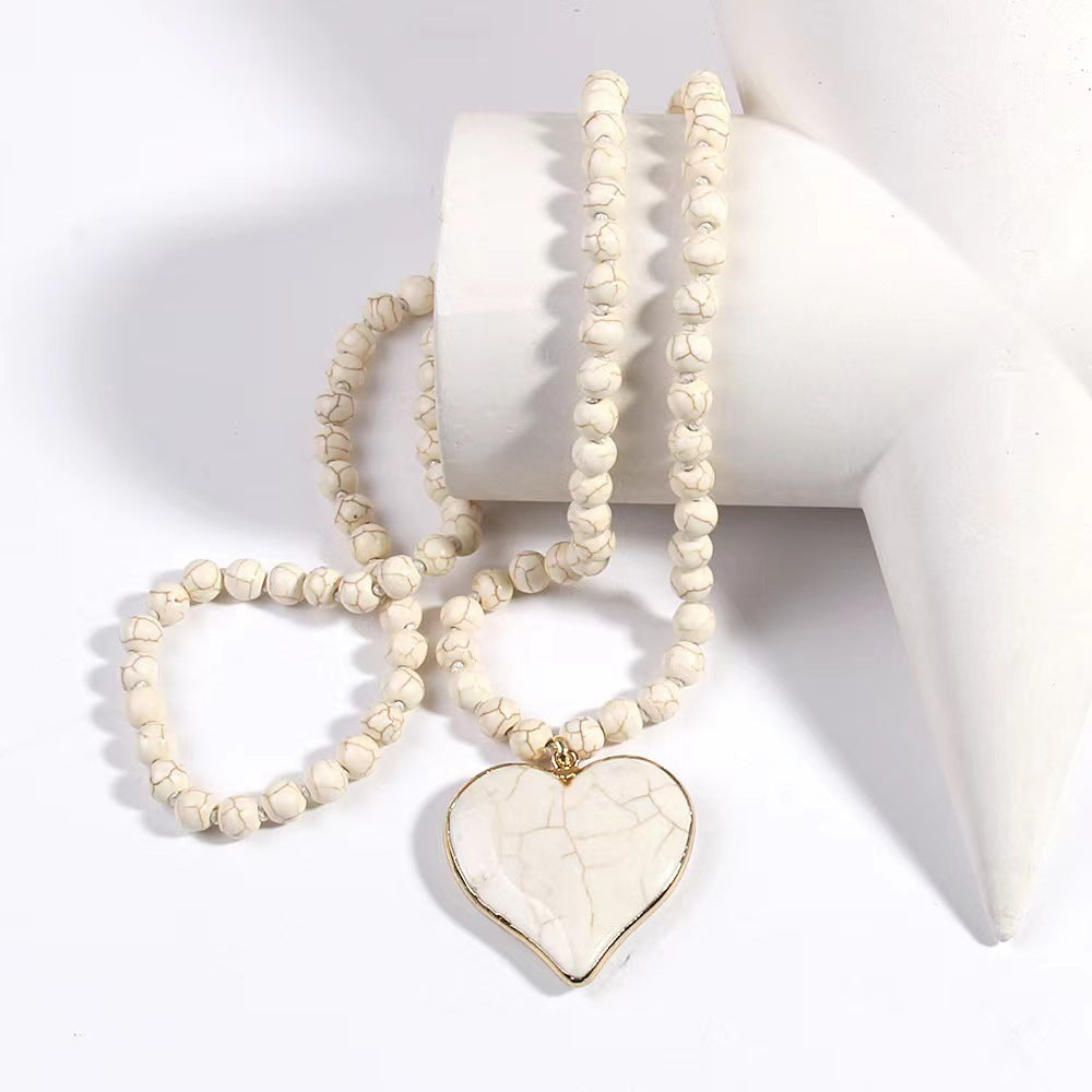 Vintage handmade knotted beaded necklace with heart-shaped mother pearl pendant and white turquoise chain.